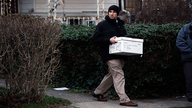 An investigator takes a box from one of the residences where suspect Edward Archer has lived Friday Jan. 8 2016 in Yeadon Pa. Archer accused of ambushing a police officer and firing shots at point-blank range said he was acting in the name of Islam