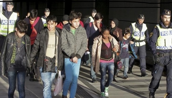 A group of migrants coming off an incoming train are seen next to police on the platform at thew Swedish end of the bridge between Sweden and Denmark in Hyllie district Malmo