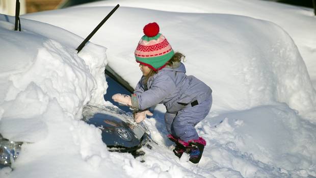 Tess Jorgensson three helps her father dig their car out of snow in Virginia