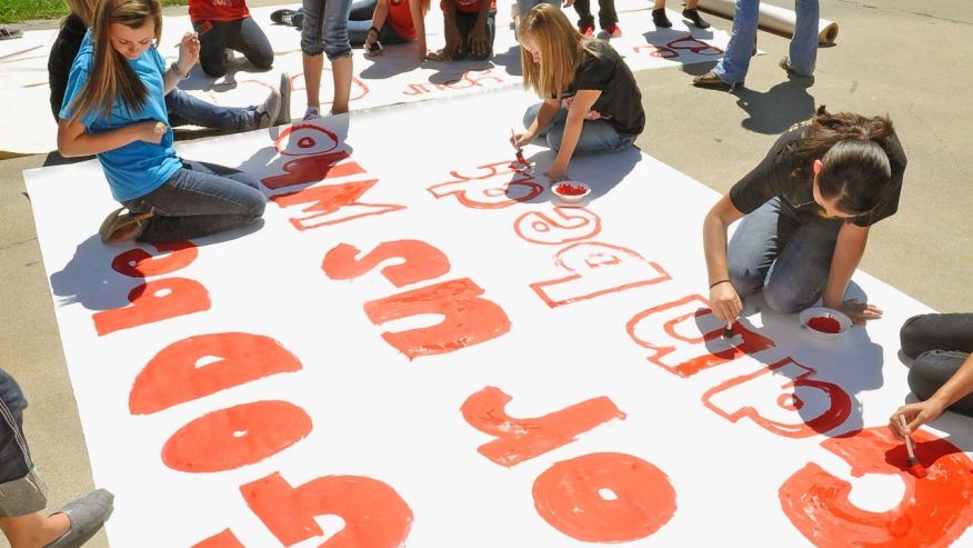 Kountze High School cheerleaders and other children work on a large banner in Kountze Texas