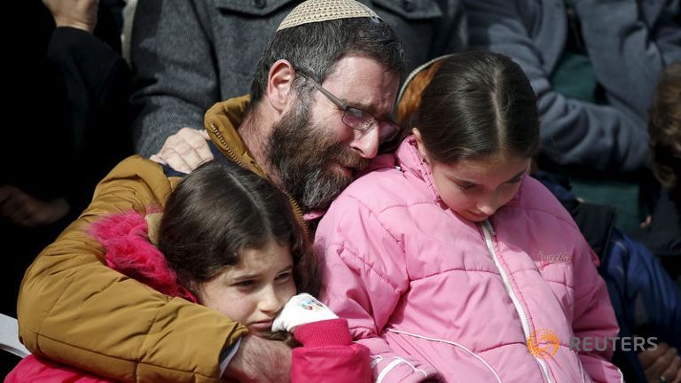 The husband and daughters of Meir mourn during her funeral at a cemetery in Jerusalem