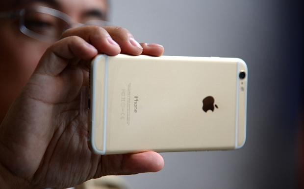 Man as he looks at his iPhone 6 Plus outside the Apple store in Pasadena California