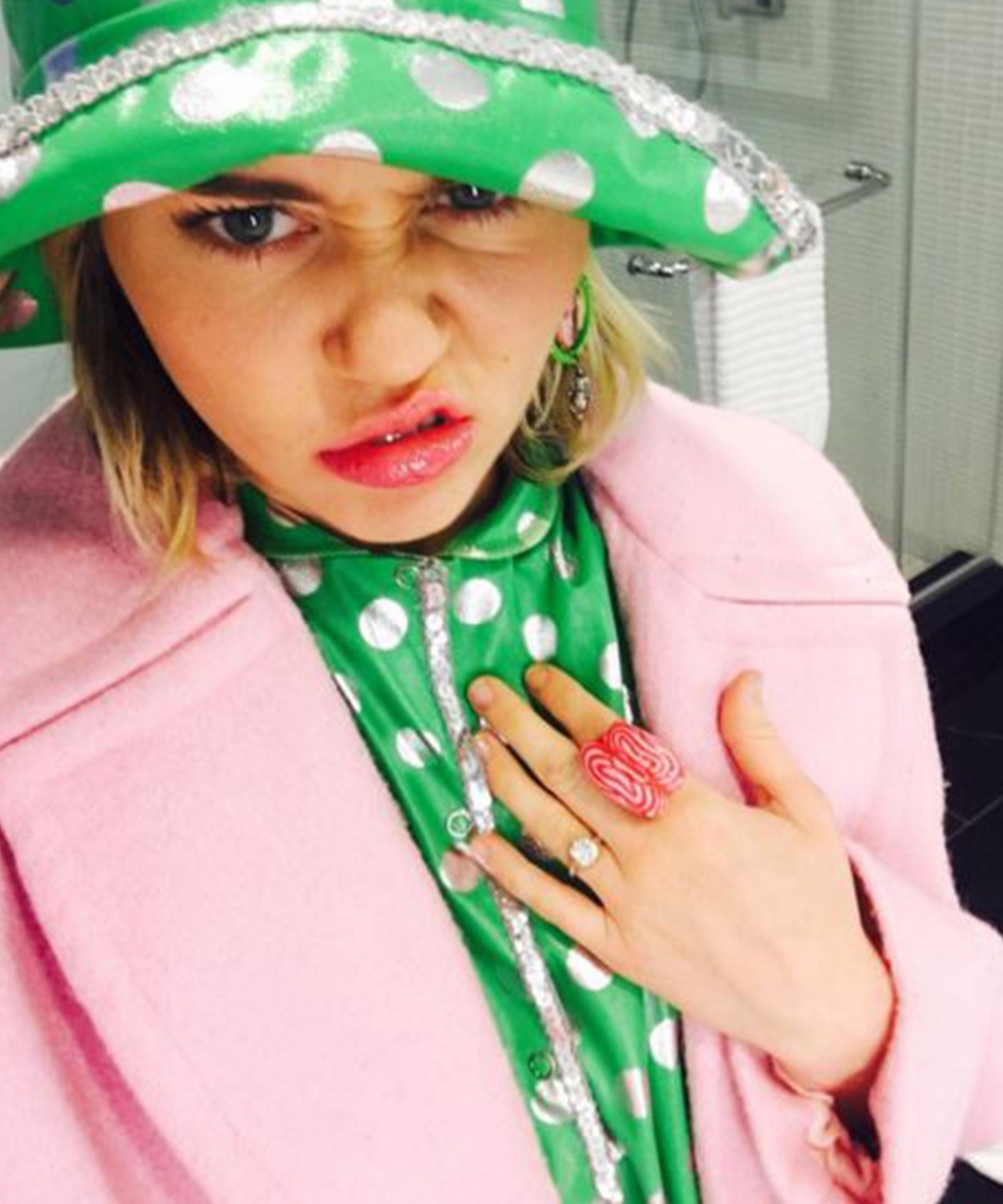 The singer was inexplicably wearing a pink jacket and green raincoat to show off her ring finger