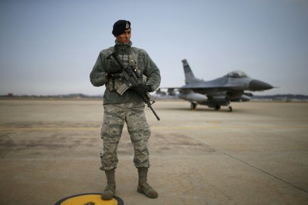 A U.S. soldier stands guard in front of their Air F-16 fighter jet at Osan Air Base in Pyeongtaek South Korea