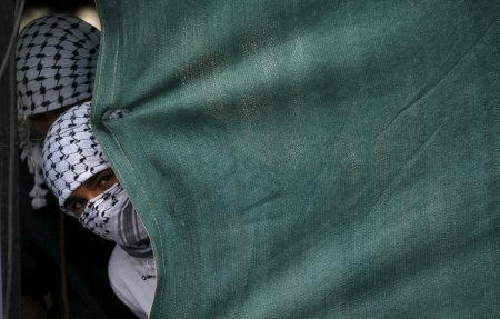 Masked young Palestinians loyal to Hamas take part in rally in Khan Younis in the southern Gaza Strip