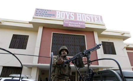 A soldier stands guard at the entrance to a dormitory where a militant attack took place in Bacha Khan University in Charsadda Pakistan