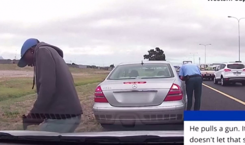 Policeman is shot in the back but continues issuing traffic ticket