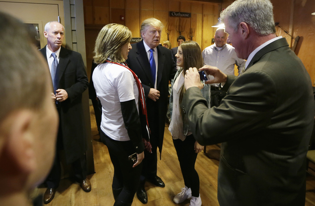 Republican presidential candidate Donald Trump talks with supporters before meeting with volunteers at the local Pizza Ranch restaurant Friday Jan. 15 201