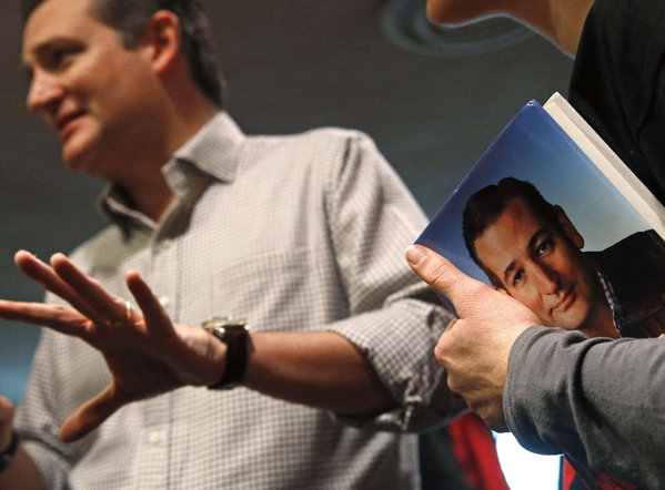 Sen. Ted Cruz speaks in Mason City Iowa as a supporter holds a book by him. He said new questions about his citizenship suggest'maybe something has changed in the race