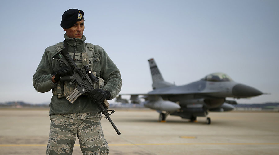 A U.S. soldier stands guard in front of their Air F-16 fighter jet at Osan Air Base in Pyeongtaek South Korea