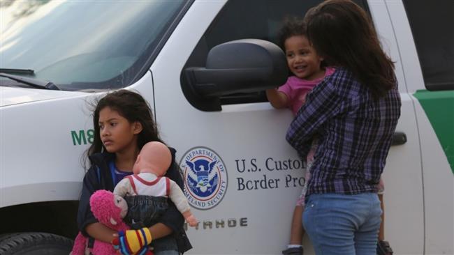 Central American immigrants await transportation to a US Border Patrol processing center after crossing the Rio Grande from Mexico into the US last year