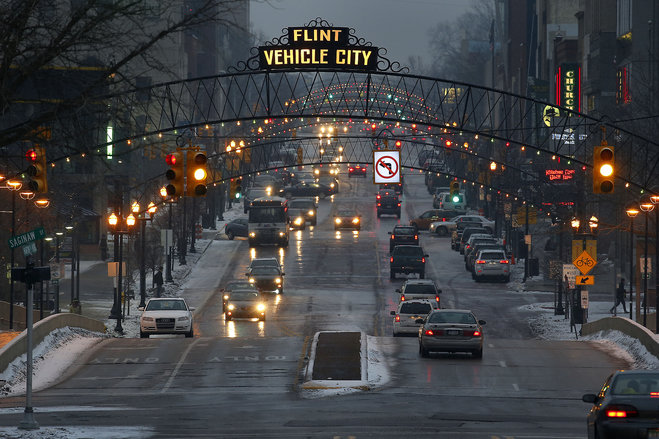 Vehicles make their way through downtown Flint Mich. Thursday Jan. 21 2016. Residents in the former auto-making hub- a poor largely minority city- feel their complaints about lead-tainted water flowing through their taps have been slighted by the