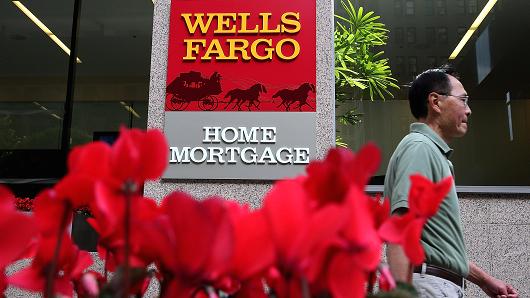 A pedestrian walks by a Wells Fargo home mortgage office in San Francisco