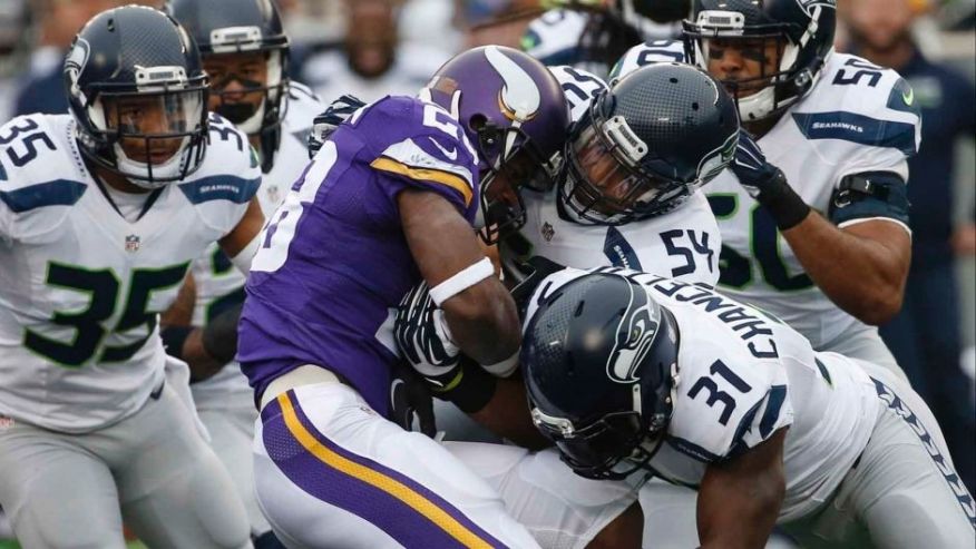 Minnesota Vikings running back Adrian Peterson is stopped by Seattle Seahawks defenders including linebacker Bobby Wagner and strong safety Kam Chancellor in the first half of an NFL football game Sunday Dec. 6 2015 in Minneapoli