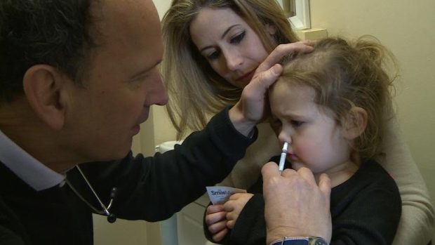 Westmount pediatrician Dr. John Yaremko gives a child-friendly nasal mist flu vaccine to a three-year-old patient