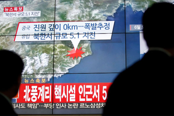 People walk by a screen showing the news reporting about an earthquake near North Korea's nuclear facility in Seoul South Korea Wednesday Jan. 6 2016