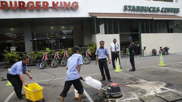 Workers clean up the spot where the militants involved in Thursday's attack were killed in Jakarta Indonesia