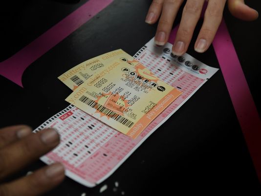 A customer picks up her California Powerball lottery tickets at the famous Bluebird Liquor store which is considered to be a lucky retailer of tickets in Hawthorne California on Jan. 13 2016