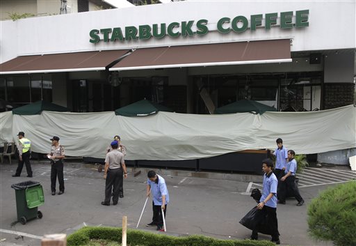 Workers clean up outside the Starbucks cafe where an attack occurred on Thursday in Jakarta Indonesia Friday Jan. 15 2016. Indonesians were shaken but refusing to be cowed a day after a deadly attack in a busy district of central Jakarta that has bee