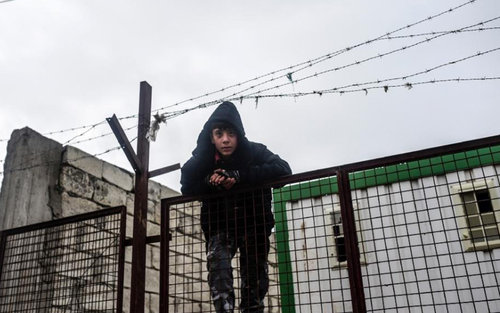 A boy on a fence in Bab Al Salam near the Turkish border