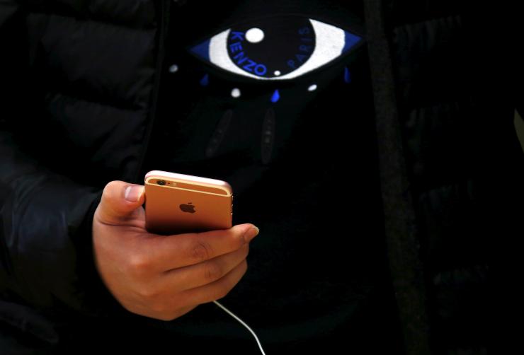 A customer holds an iPhone 6s during the official launch at the Apple store in central Sydney Australia