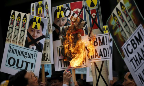 A man burns banners being held by protesters during an anti North Korea rally in central Seoul on Feb. 11 2016. /Reuters