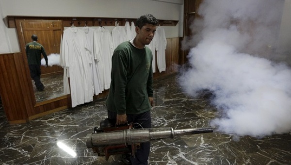 A municipal worker fumigates inside the parsonage of a church to help control the spread of the mosquito-borne Zika virus in Caracas