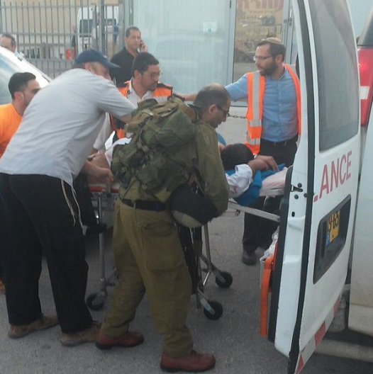 A victim being transported into an ambulance outside the West Bank supermarket where Palestinian teens went on a stabbing spree