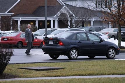 A worker directs traffic in the parking lot of a Blacksburg funeral home on Wednesday