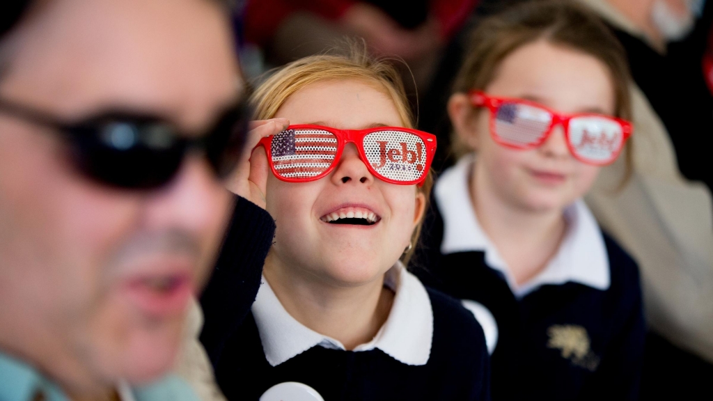 A young girl watches as Republican presidential candidate Jeb Bush arrives to speak at a rally in South Carolina