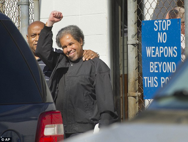 Albert Woodfox right raises a clenched fist as he walks out of the West Feliciana Detention Center with his brother Michael Mable on Friday