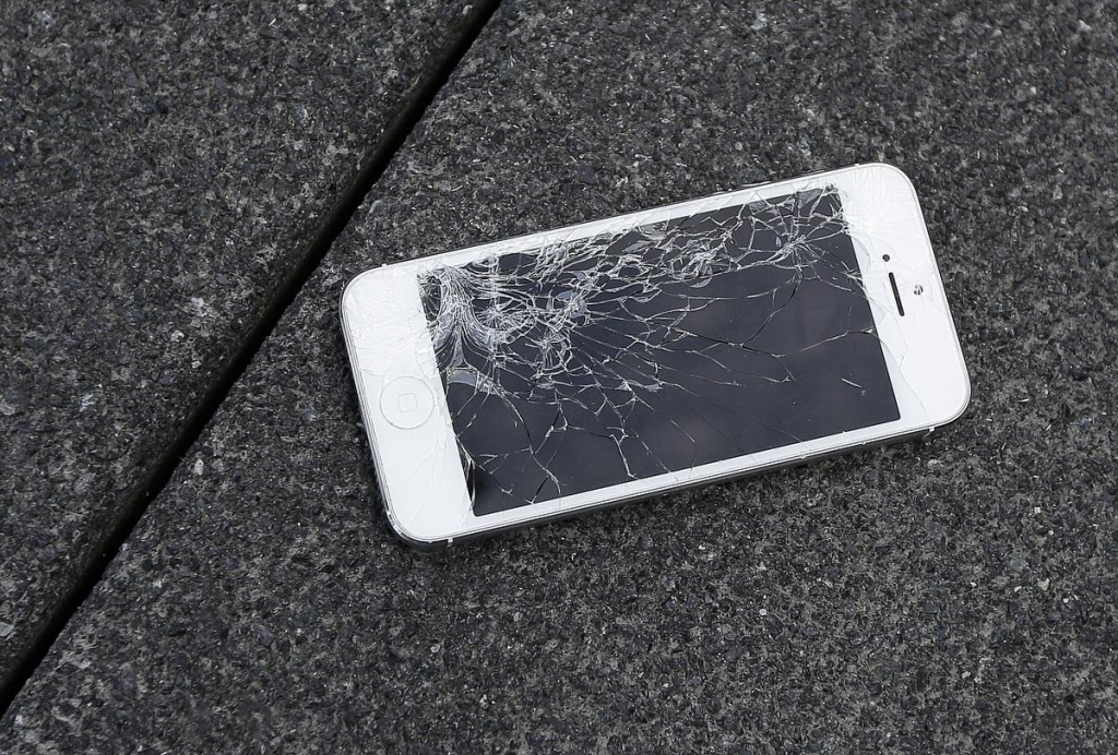 An Apple iPhone with a cracked screen- the kind of phone the company now will accept as a trade-in., BEN MARGOT AP FILE