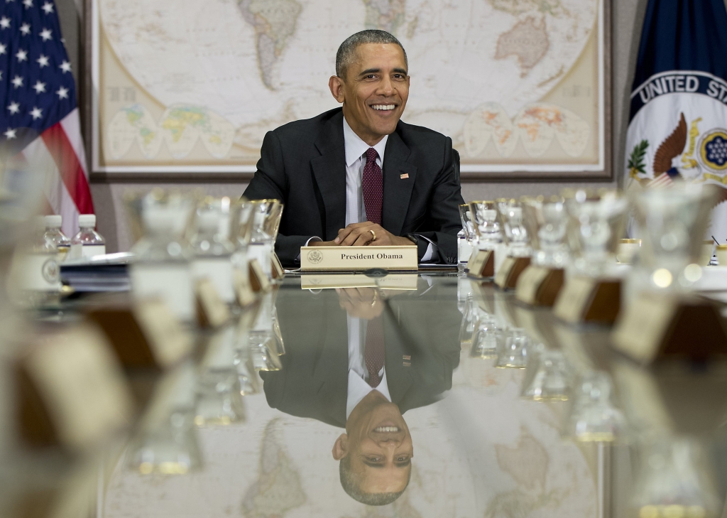 President Barack Obama is reflected in the conference table before a meeting of his National Security Council at the State Department in Washington Thursday Feb. 25 2016. The meeting is to focus on the global campaign to degrade and destroy ISIL