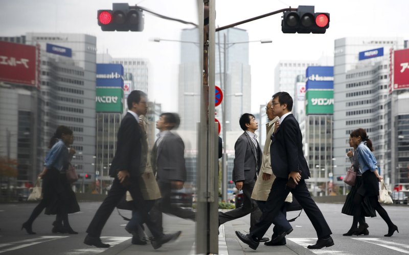 People cross a street in a business district in central Tokyo Japan