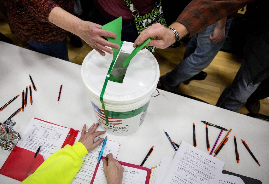 Caucus-goers cast their ballots at Pella High School in Pella Iowa on Monday. up New Hampshire