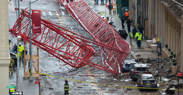 A collapsed crane fills the street on Friday Feb. 5 2016 in New York. The huge construction crane was being lowered to safety in a snow squall when plummeted onto the street in the Tribeca neighborhood of lower Manhattan