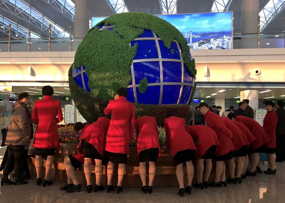 North Korea's women soccer team fills up custom forms in front of a globe structure as they prepare for departure from Pyongyang to Beijing on Tuesday Feb. 23 2016 at Pyongyang's International Airport in Pyongyang North Korea