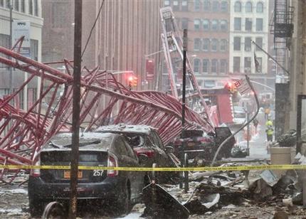 A collapsed crane crushed cars along the street on Friday Feb. 5 2016 in New York. The crane landed across an intersection and stretched much of a block in the Tribeca neighborhood about 10 blocks north of the World Trade Center. (AP