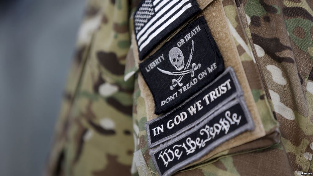 Patches on the sleeve of a militiaman are seen at the Malheur National Wildlife Refuge near Burns Oregon site of a takeover by self-styled militiamen who were protesting the federal government's role in governing wild lands Jan. 4 2016