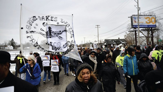 Demonstrators walk during a mile-long march to the City of Flint Water Plant Feb. 19 in Flint. Mich