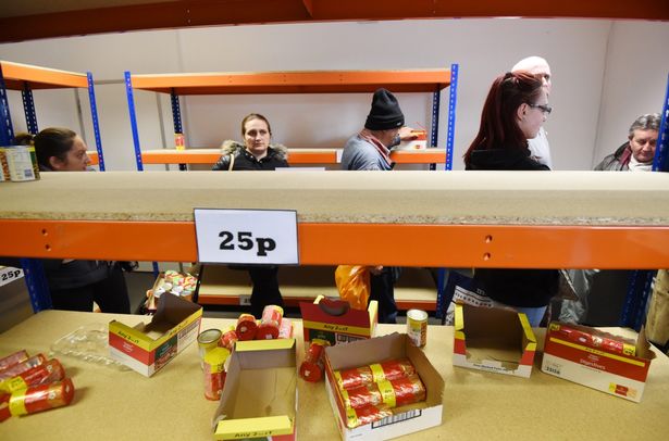 Customers clear the shelves of the new easy Foodstore budget supermarket in Park Royal North London