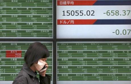 A woman walked past an electronic stock board showing Japan’s Nikkei 225 in Tokyo on Friday