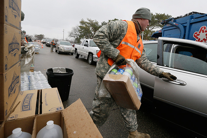 Members of the Michigan National Guard load bottled water for residents at a fire station Thursday Jan. 28 2016 in Flint Mich