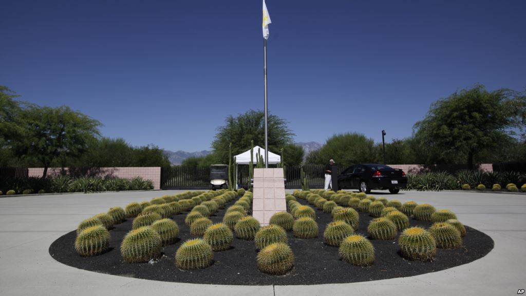 FILE- A security guard talks to a visitor at the entrance to the Annenberg Retreat at Sunnylands in Rancho Mirage Calif. Wednesday