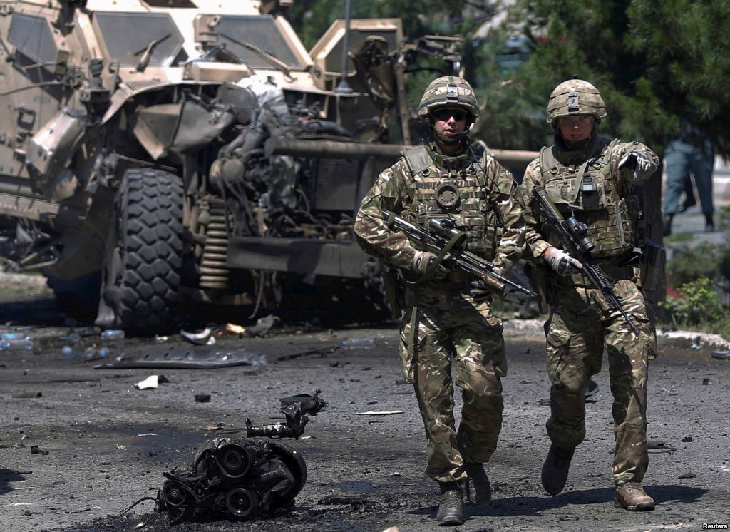 FILE- NATO soldiers walk at the site of a suicide bomb attack in Kabul Afghanistan