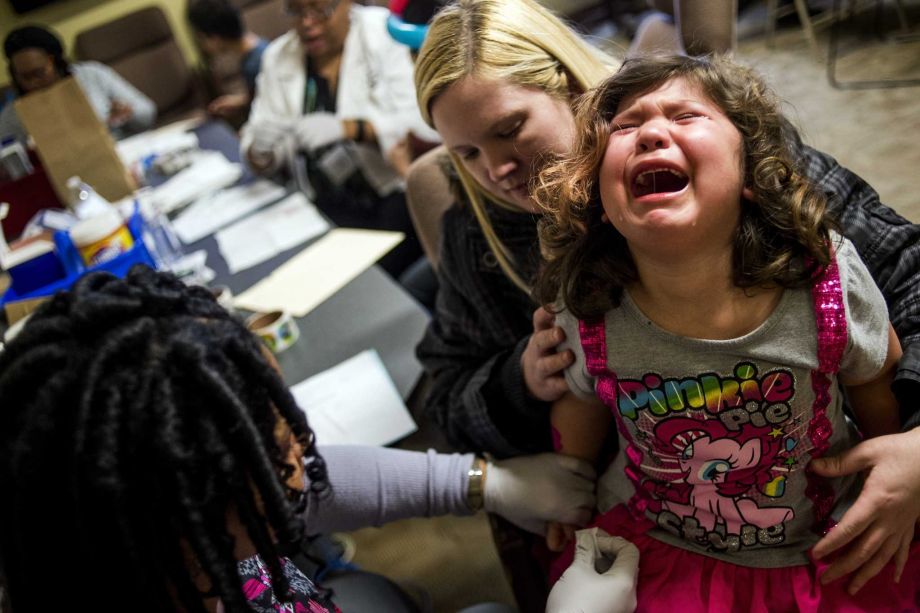 Health care providers are offering free lead tests for children in Flint bringing in Sarah Truesdail who holds her daughter Gabriella Venegas 5 as a health worker pricks her finger