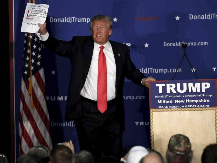 Republican presidential candidate Donald Trump holds a sheet of paper with his notes on it as he speaks at a campaign rally in Milford New Hampshire