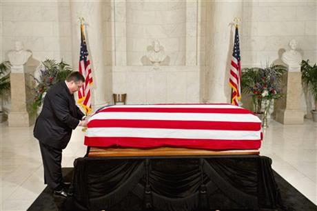 The flag covering the casket of late Supreme Court Justice Antonin Scalia is adjusted by funeral home staff before the doors opened to the public in the Great Hall of the Supreme Court in Washington Friday Feb. 19 2016