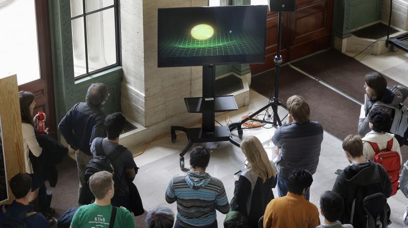 Massachusetts Institute of Technology students gather around a monitor in an overflow area on the MIT campus to watch an update by scientists on the discovery of gravitational waves