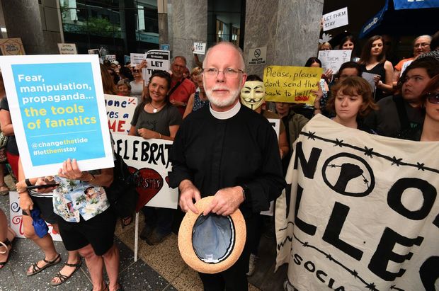 Anglican Dean of Brisbane Dr Peter Catt attends a pro-refugees protesters rally outside the Immigration Office in Brisbane Friday Feb. 5 2016. The protest comes days after a High Court ruling that paves the way for 267 asylum seekers including babies